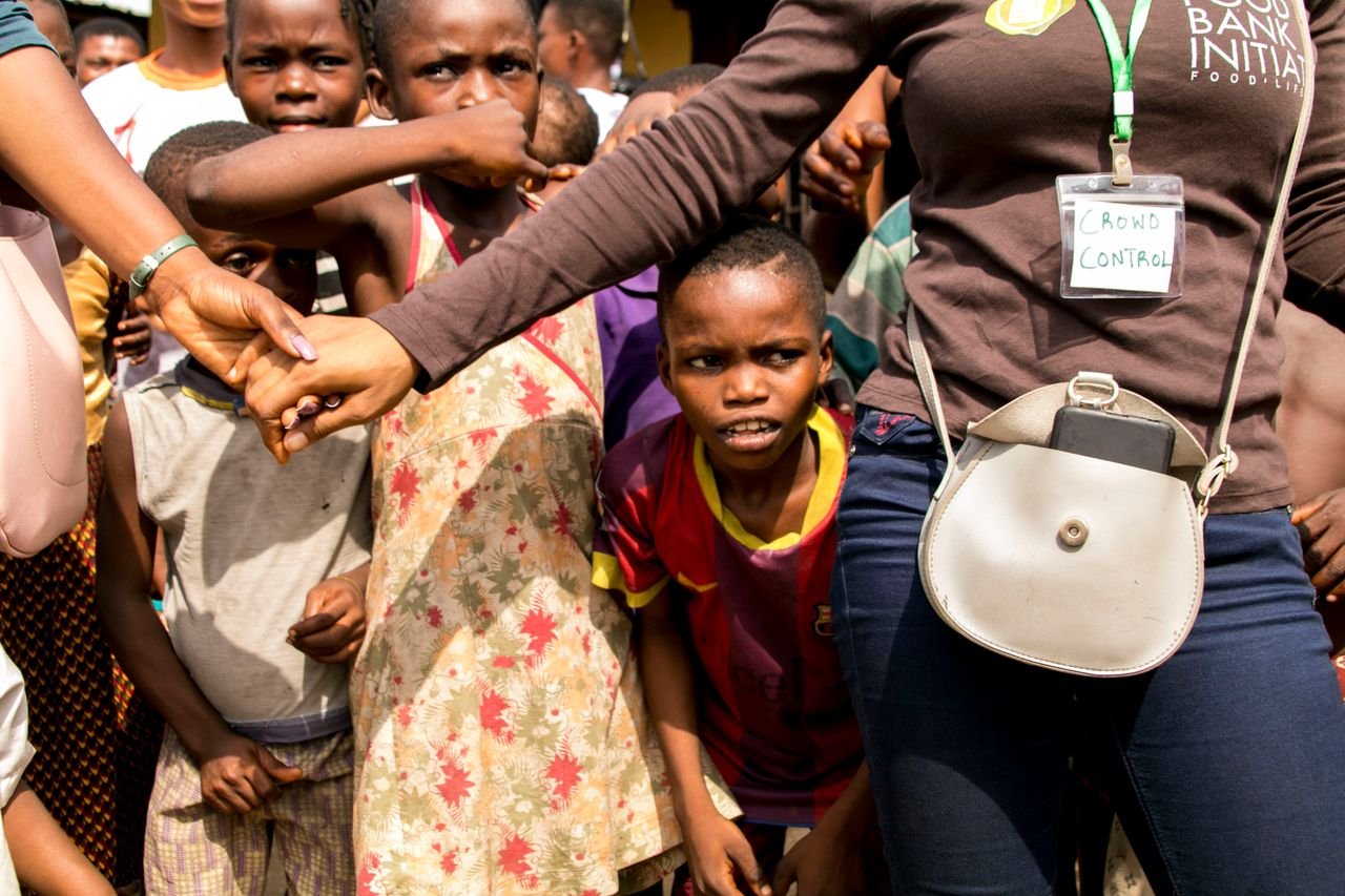 Children gathered with security personnel at a community event, promoting safety.